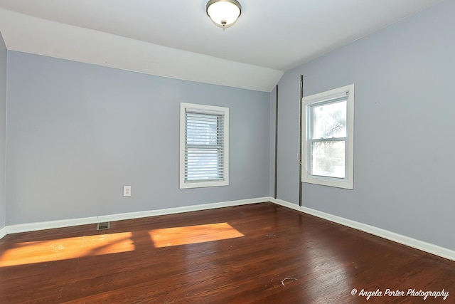 empty room featuring dark hardwood / wood-style flooring and lofted ceiling