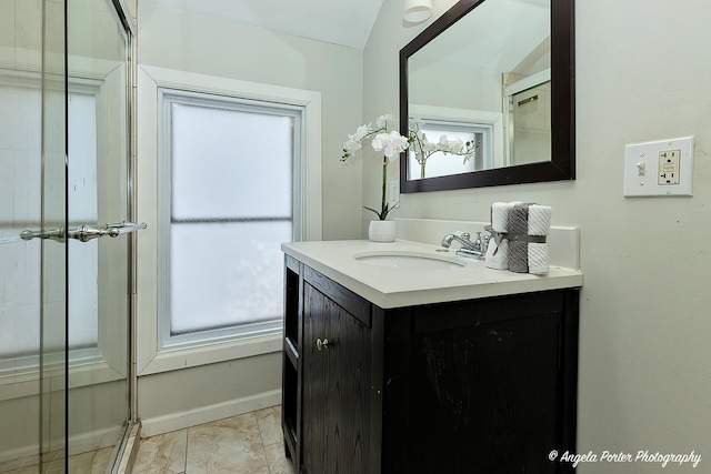 bathroom with vanity, vaulted ceiling, and a wealth of natural light