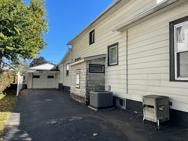 view of home's exterior featuring an outbuilding, central AC unit, and a garage