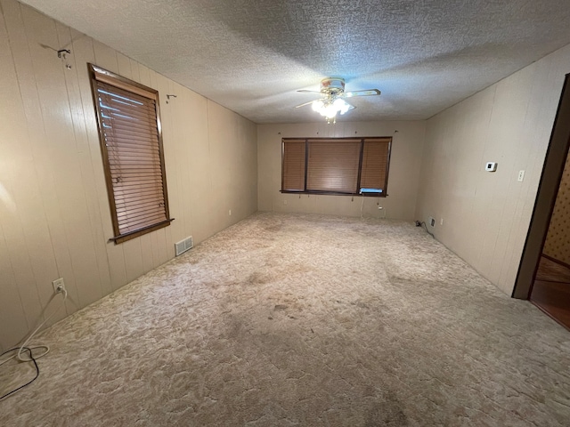 carpeted empty room with a textured ceiling and ceiling fan