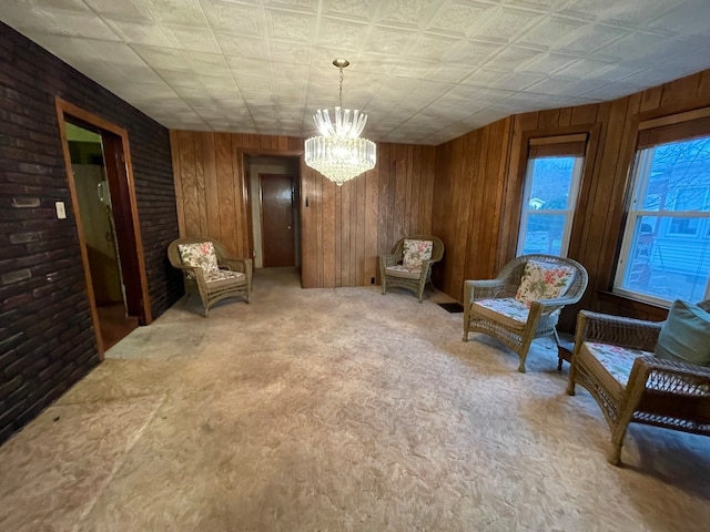 living area with a notable chandelier and wood walls