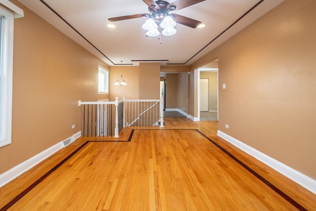 corridor featuring an inviting chandelier and wood-type flooring