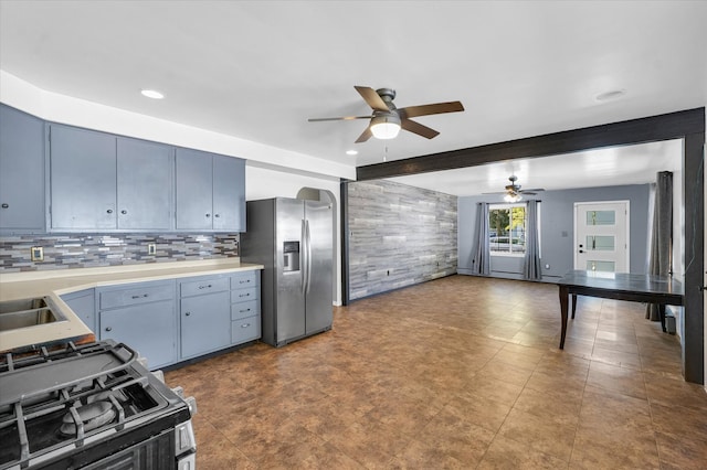 kitchen featuring blue cabinets, ceiling fan, beam ceiling, backsplash, and stainless steel appliances