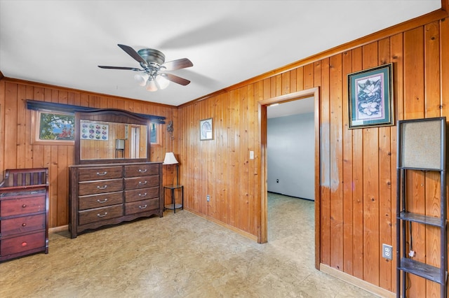 bedroom featuring crown molding, ceiling fan, and wood walls