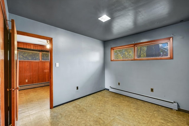 empty room featuring plenty of natural light and baseboard heating