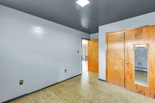 unfurnished bedroom featuring a closet and a baseboard heating unit