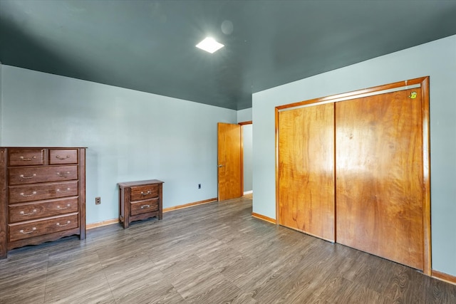 unfurnished bedroom with wood-type flooring and a closet