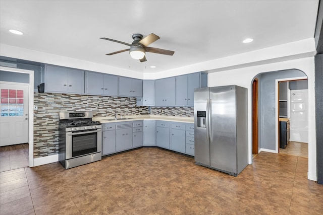 kitchen with ceiling fan, backsplash, stainless steel appliances, and blue cabinets