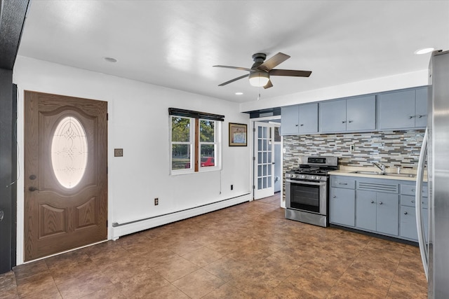 kitchen with ceiling fan, sink, baseboard heating, backsplash, and appliances with stainless steel finishes