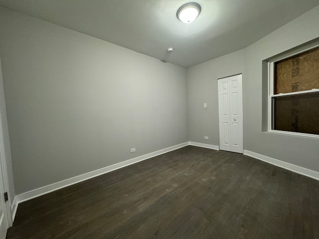 unfurnished room with dark wood-type flooring