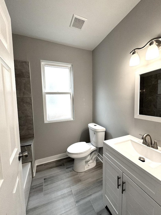 6830 S Michigan Ave, Chicago, IL 60637 - bathroom with toilet, vanity, baseboards, and wood finished floors