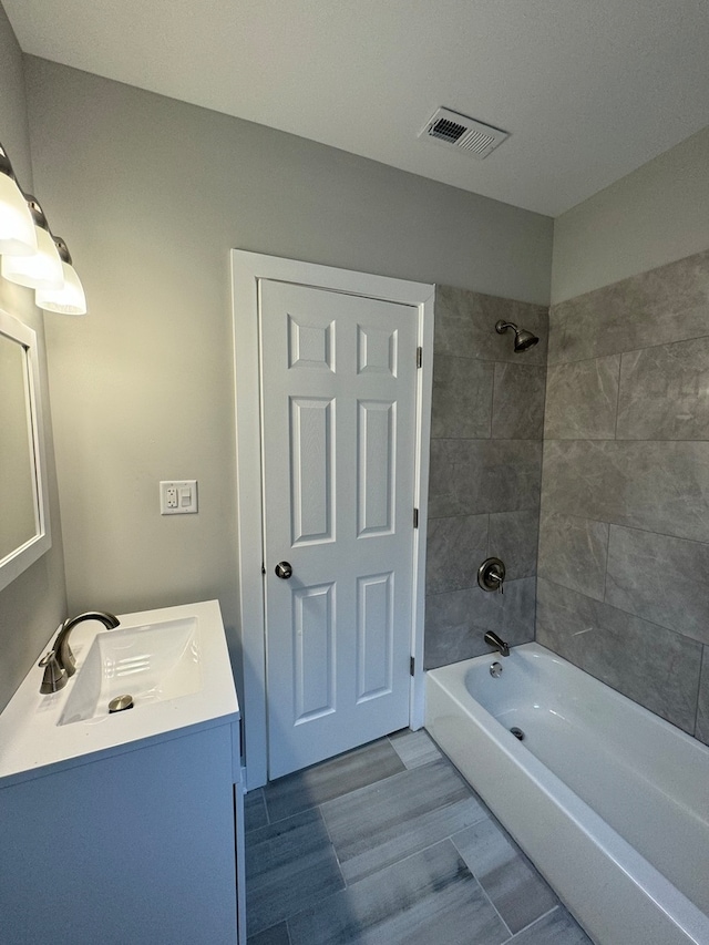 bathroom featuring vanity and tiled shower / bath combo