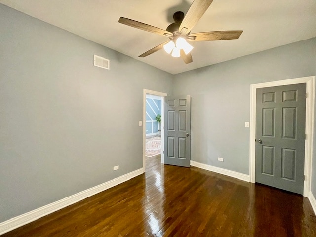 spare room featuring ceiling fan and dark wood-type flooring