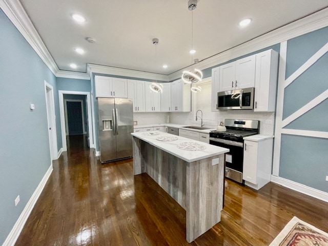 kitchen with pendant lighting, white cabinetry, appliances with stainless steel finishes, and a kitchen island