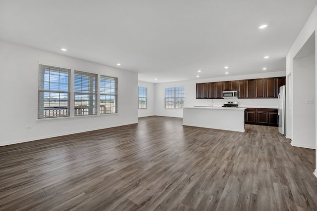 unfurnished living room featuring sink and light hardwood / wood-style floors