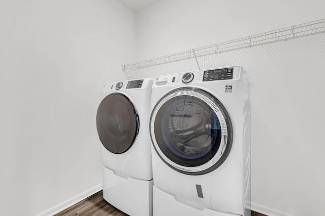 washroom featuring dark hardwood / wood-style flooring and washing machine and clothes dryer