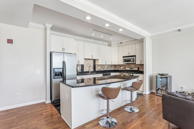 kitchen featuring decorative backsplash, white cabinetry, dark wood-type flooring, stainless steel appliances, and crown molding