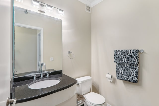 bathroom with crown molding, vanity, and toilet