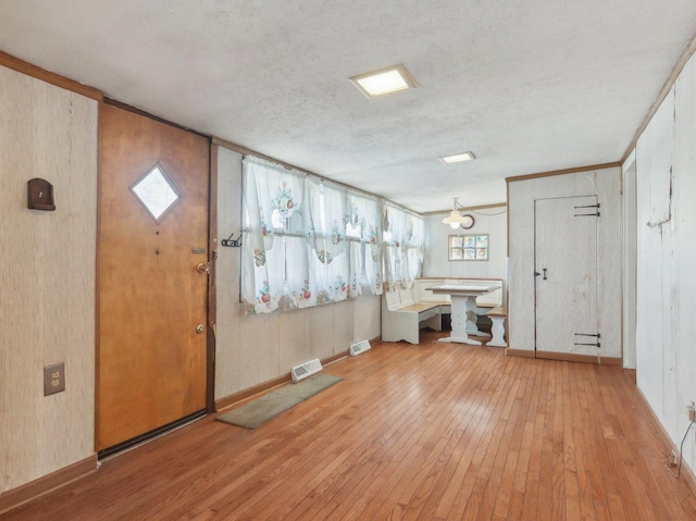 entryway with a textured ceiling and light wood-type flooring