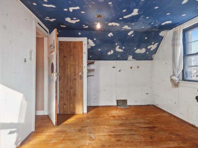 bonus room with hardwood / wood-style floors and vaulted ceiling