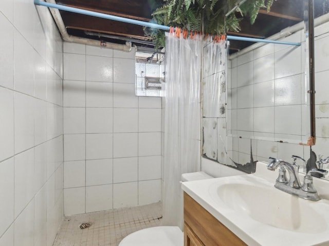 bathroom featuring toilet, a tile shower, and vanity