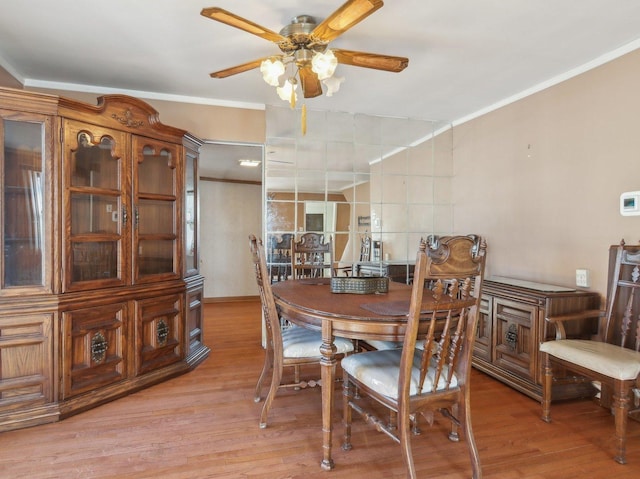 dining room with light hardwood / wood-style floors, ceiling fan, and crown molding