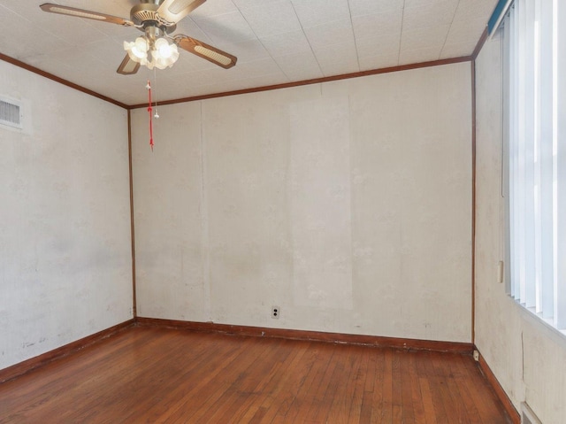 spare room featuring crown molding, ceiling fan, and dark wood-type flooring