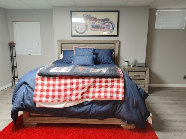 bedroom with a paneled ceiling and hardwood / wood-style floors