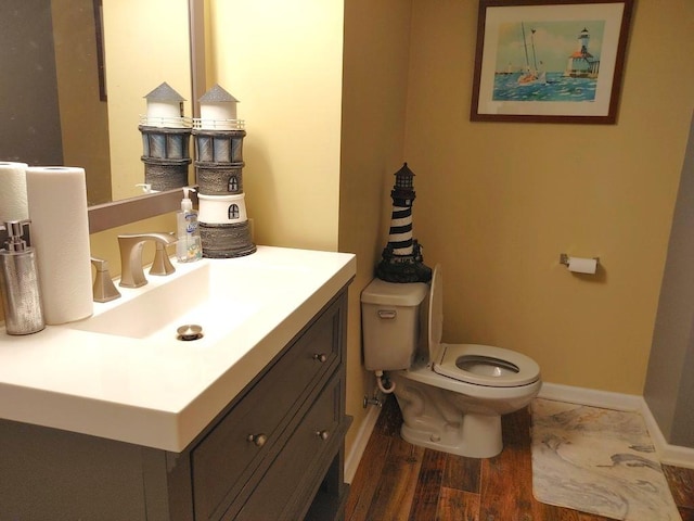 bathroom with hardwood / wood-style floors, vanity, and toilet