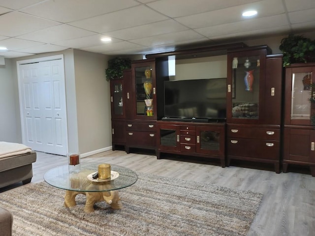 living room with a paneled ceiling and light hardwood / wood-style floors