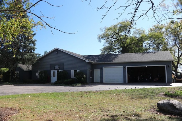 ranch-style house featuring a garage and a front lawn