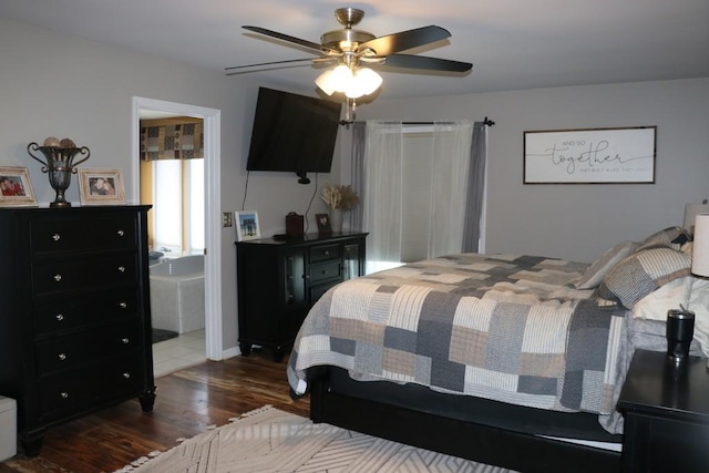 bedroom with ensuite bath, ceiling fan, and dark wood-type flooring