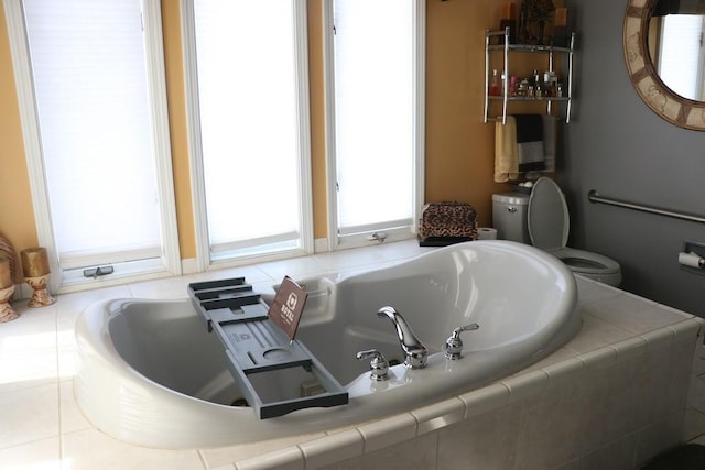 bathroom featuring tiled bath and toilet