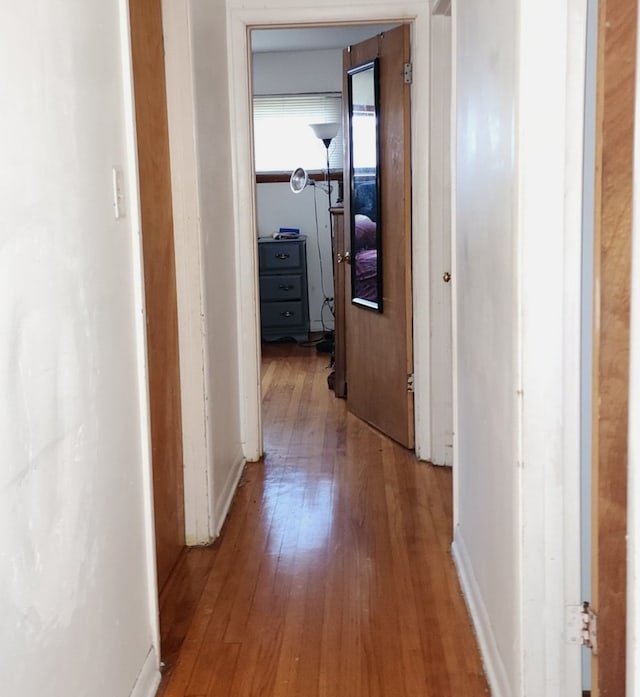 hallway with hardwood / wood-style floors