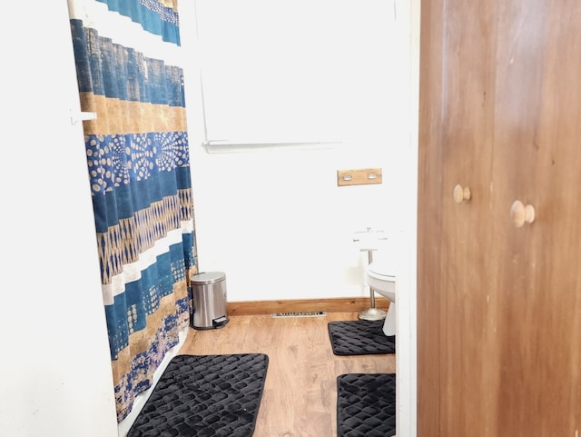 bathroom featuring walk in shower and hardwood / wood-style floors