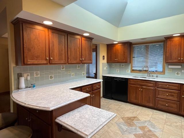 kitchen featuring dishwasher, sink, vaulted ceiling, decorative backsplash, and light tile patterned floors