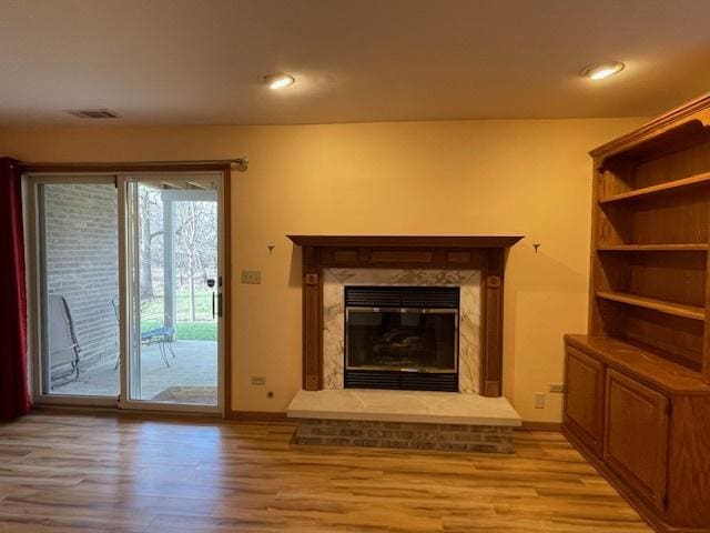 unfurnished living room with light wood-type flooring and a fireplace