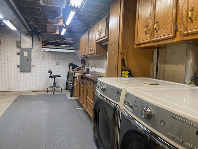 laundry area featuring electric panel and washing machine and clothes dryer