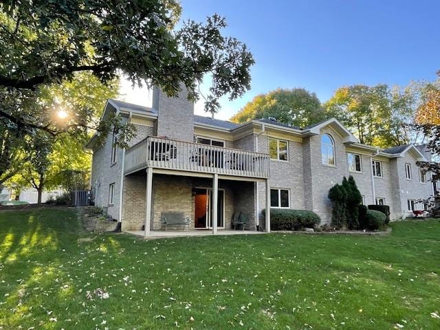 back of property with a deck and a lawn