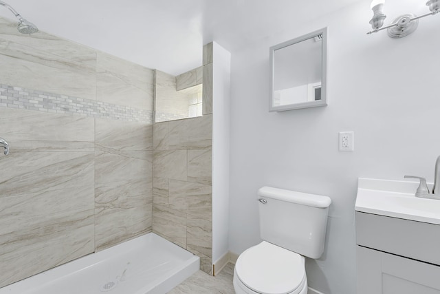 bathroom featuring tiled shower, vanity, and toilet