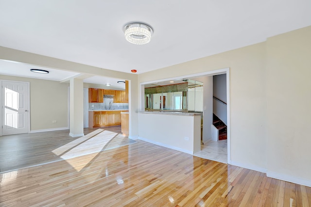 unfurnished living room featuring light wood-type flooring and sink