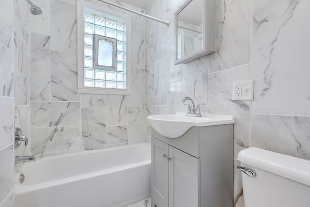 full bathroom featuring tile walls, tiled shower / bath combo, vanity, and toilet