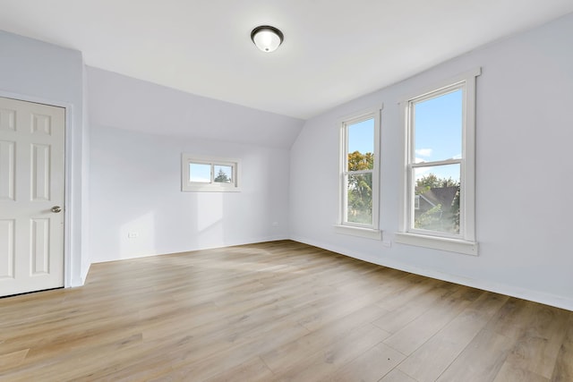 bonus room with light hardwood / wood-style flooring, vaulted ceiling, and a healthy amount of sunlight