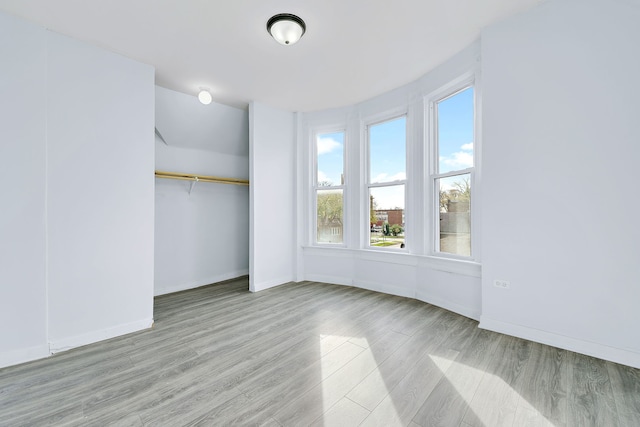 unfurnished bedroom with light wood-type flooring and a closet