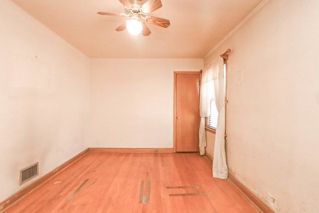 empty room with ceiling fan, ornamental molding, and light wood-type flooring