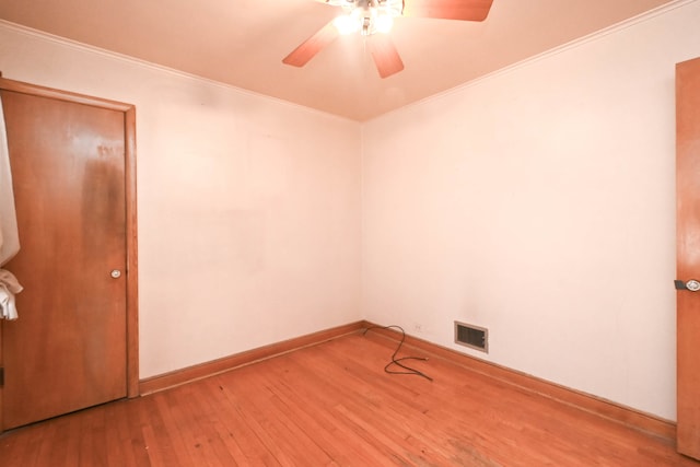 empty room featuring ceiling fan, hardwood / wood-style flooring, and ornamental molding