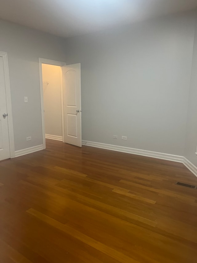 interior space featuring dark wood-style floors, visible vents, and baseboards