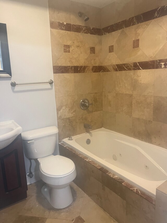 full bathroom with tile patterned flooring, tiled shower / bath, vanity, and toilet