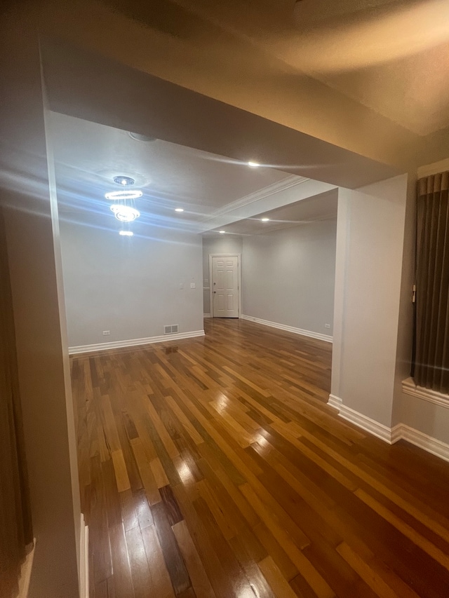 below grade area with visible vents, baseboards, and dark wood-type flooring