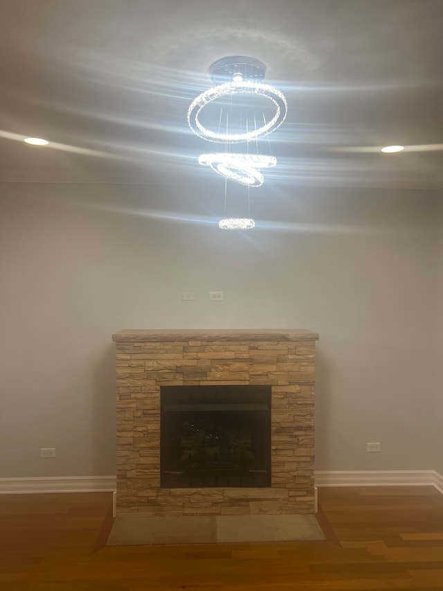 interior details featuring baseboards, wood finished floors, and a stone fireplace